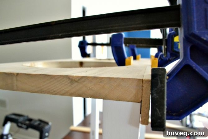 Use clamps to hold the sides of your no-slip dog feeder in place as the glue dries. 