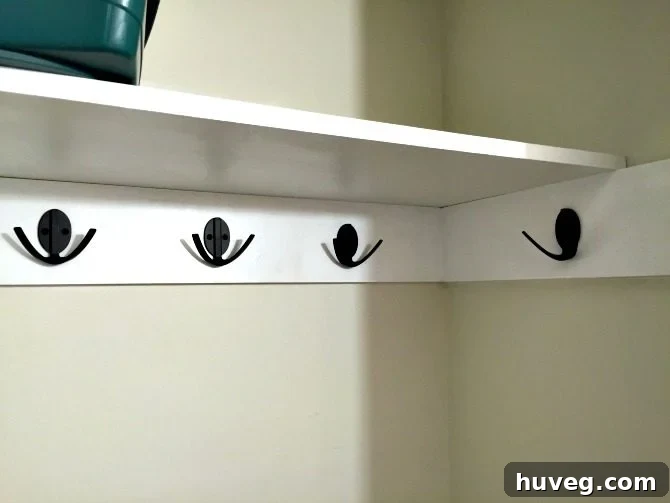 Upgraded Closet Shelf with New Black Robe Hooks by National Hardware