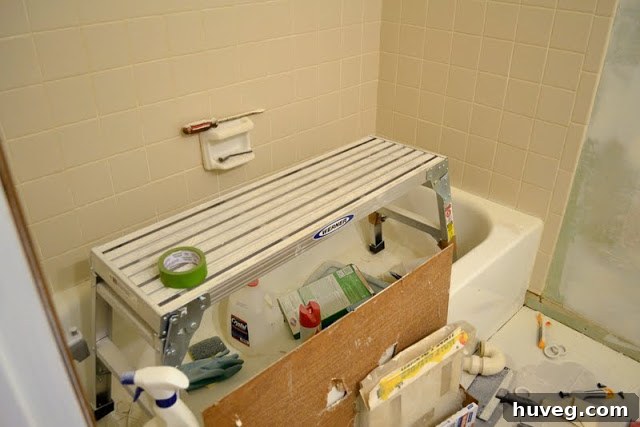A cluttered guest bathroom during renovation, filled with tools and materials.