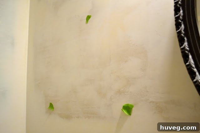 Close-up of a wall marked with painter's tape, ready for final sanding.