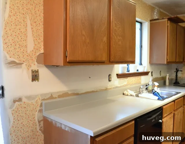 Kitchen wall nearly clear of wallpaper