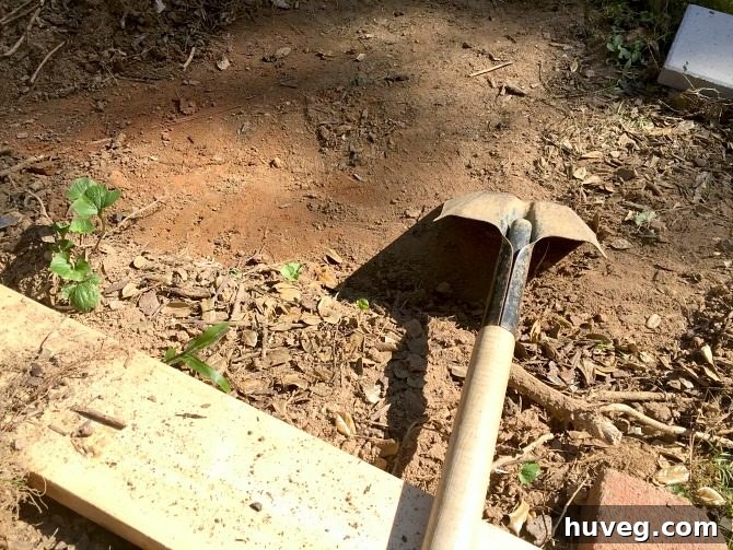 Using a shovel's edge to meticulously create a straight, clean line for the concrete pad excavation
