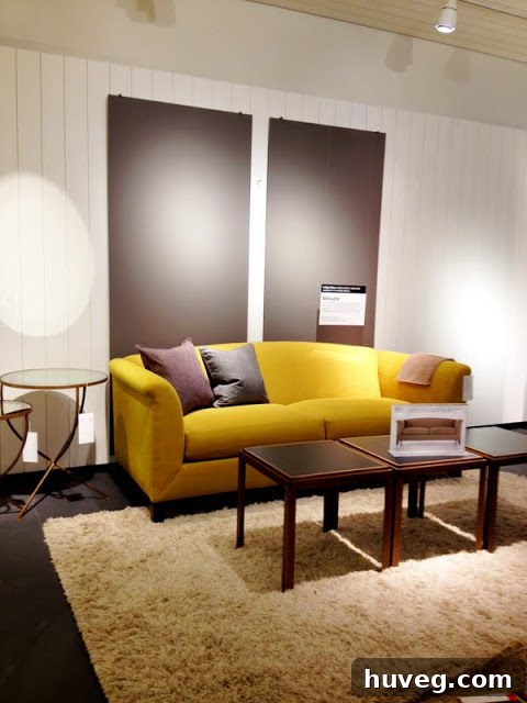 Elegant yellow Silhouette Sofa paired with a white shag rug at Crate & Barrel