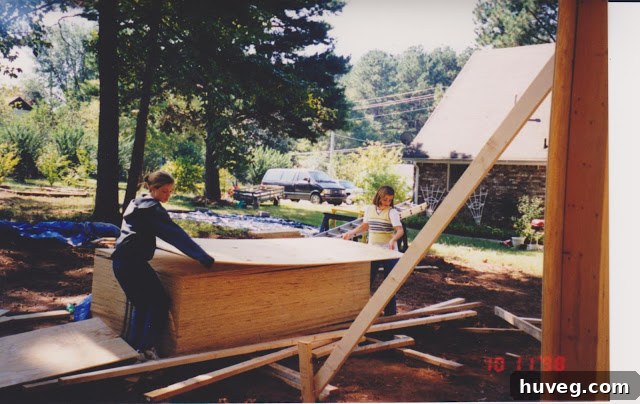 Two young girls (the author and her sister) working alongside their dad on a construction project, specifically building a garage, captured in a vintage photograph.