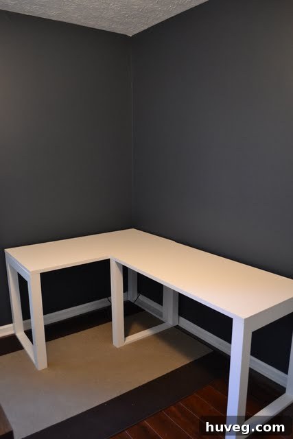 A transitional shot showing one wall in navy and an adjacent wall with a light gray primer or base coat.