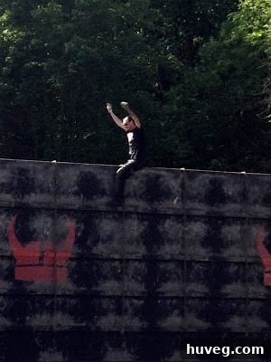 A blind Warrior Dash participant being guided through a muddy section of the obstacle course.