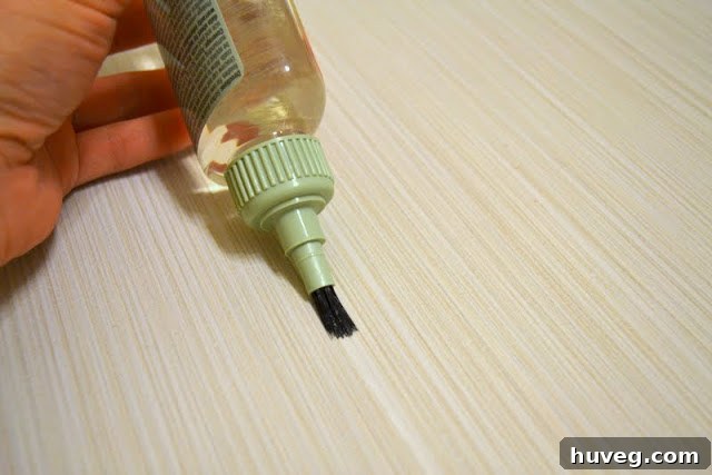 Someone applying grout sealer with a small brush, emphasizing ease of use