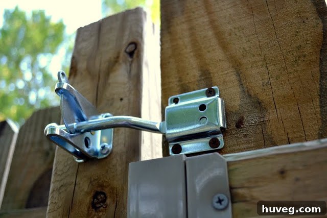 A weathered wooden gate with a broken latch, showing signs of disrepair and neglect