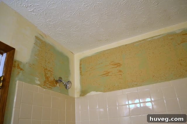 Guest bathroom walls after successful wallpaper removal, showing the bare drywall ready for repair and new finishes.
