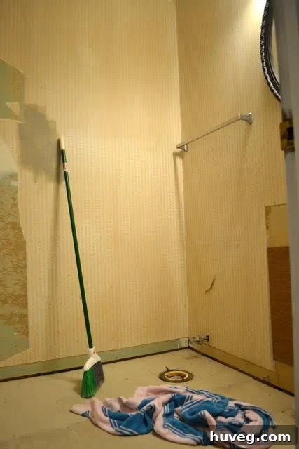 Demolition debris and tools in the guest bathroom, highlighting the ongoing renovation.