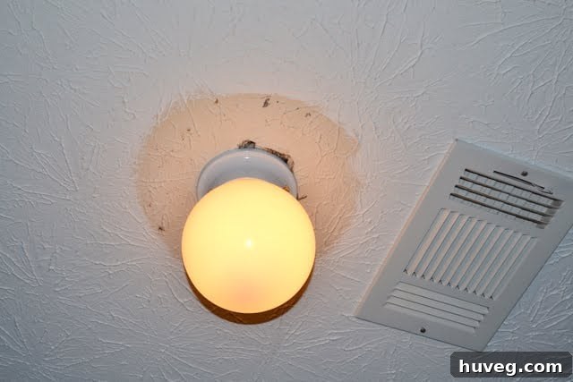 Unpainted ceiling area around a temporary ceiling fan replacement