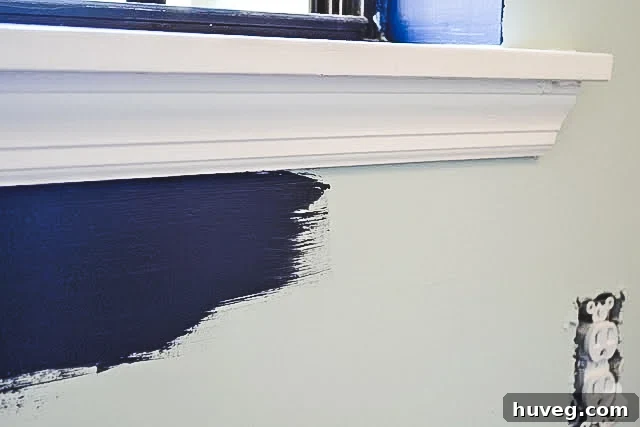 Close-up of a painter's hand skillfully cutting in a straight line on a wall without using tape