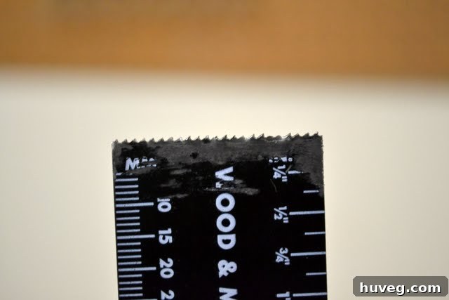 Close-up of the oscillating tool blade, showing its intact teeth after cutting metal