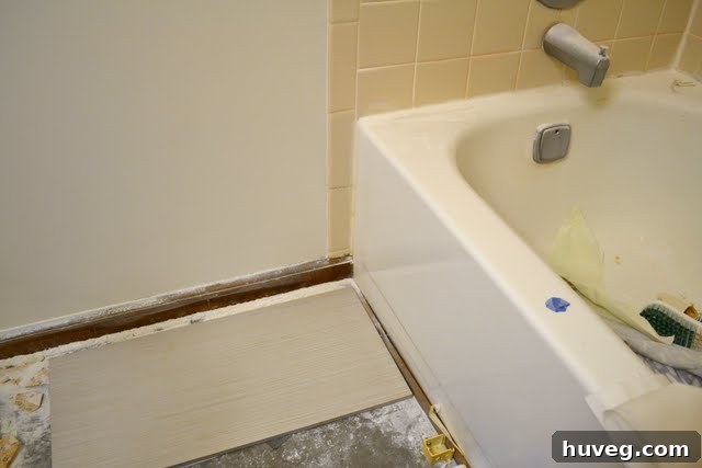 Closer look at the tile sample next to existing shower tile, demonstrating the match