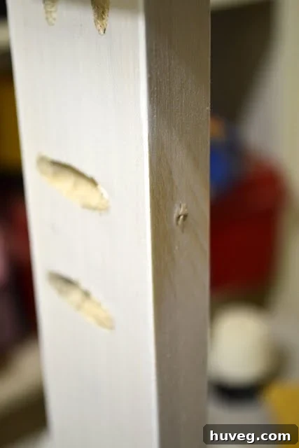 Close-up of DIY desk frame joint, showing screw connections and wood grain details.