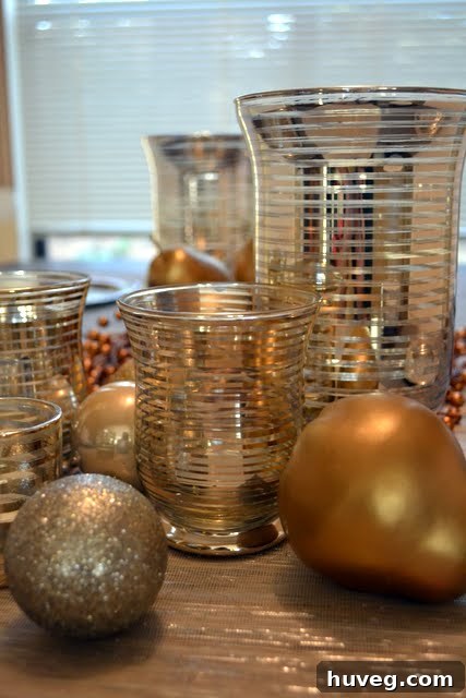 Close-up of a festive Christmas table setting, featuring silver and gold accents, twinkling lights, and evergreen decorations.