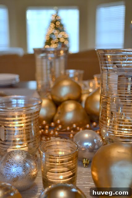 Close-up of a Christmas table with silver and gold ornaments reflecting soft light, creating a warm and inviting glow.