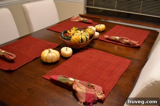 Assortment of small, colorful decorative gourds and squash on a rustic surface