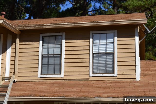 Side view of a house exterior, showing extensive progress on the new paint job