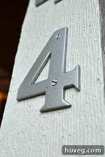Painted house numbers displaying a modern and cohesive look on the home exterior, matching other hardware
