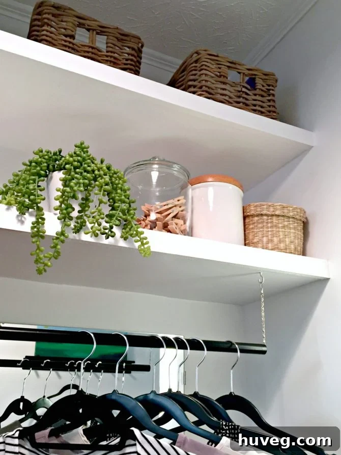 New laundry room shelves and a hanging rod, with a ceramic container on the shelf.