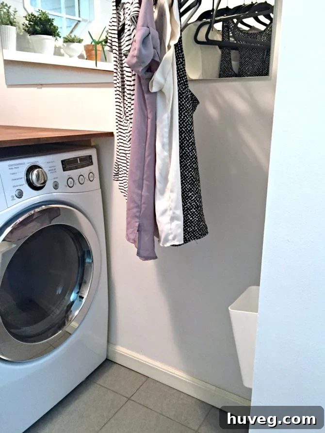 Hanging clothes and the new, smaller trash can in the laundry room.