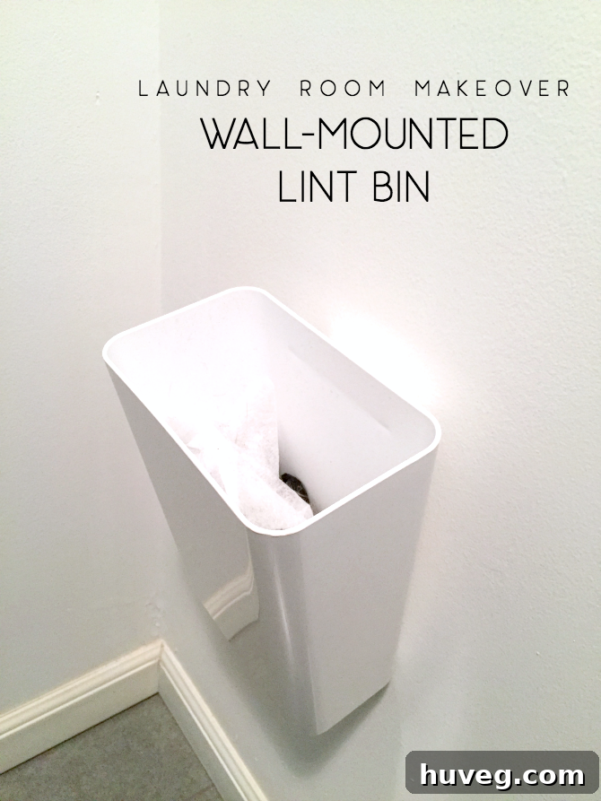 Wall-mounted lint trash can in the laundry room, blending with the white wall.