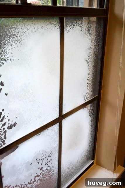 Hand wiping away Fish Foam from a window with a microfiber cloth