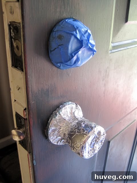 Doorknobs and deadbolt covered with tape and foil for protection