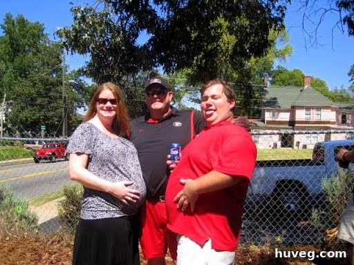 Shannon and her husband JJ comparing baby bumps with a fraternity brother at a college football gameday.