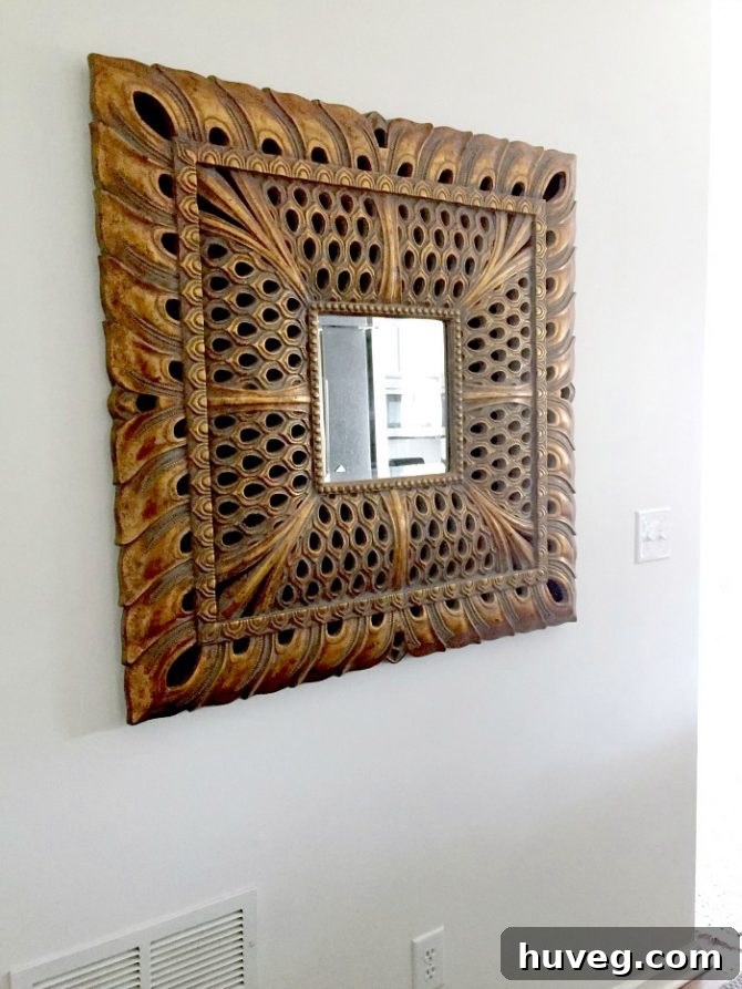 Large square peacock mirror adds grandeur to the entryway hallway
