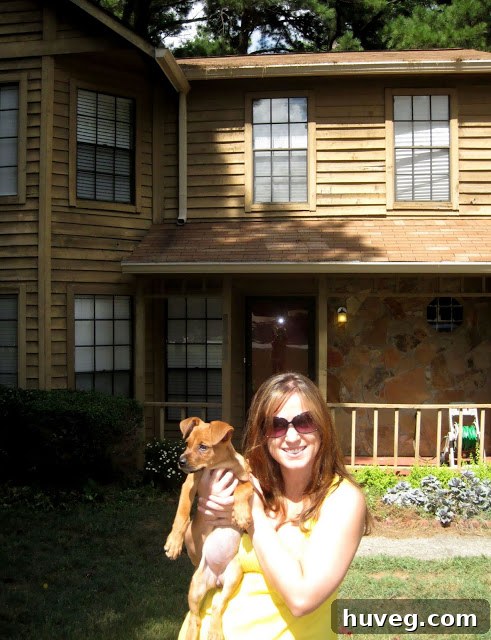 The author holding her puppy, Charlie, proudly in front of their first house. A symbol of new beginnings.