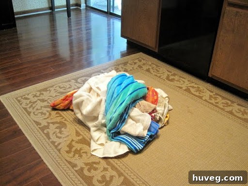 Piles of clean laundry on a shiny kitchen floor.