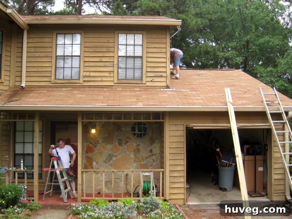 Exterior wall section with damaged siding being removed, revealing dry rot and deteriorated wood underneath, emphasizing the extent of repairs needed.