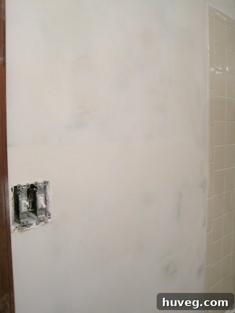 Close-up of a newly smoothed bathroom wall section, showing a flawless finish.