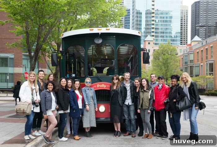 Group of bloggers embarking on a guided trolley tour of Chicago's architectural wonders, with a historical building in the background.