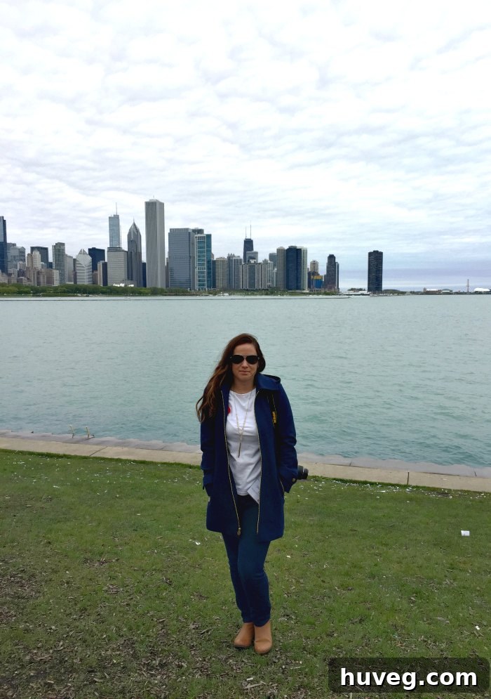 Sarah Fogle stands on a Chicago street, with the iconic skyline gracefully stretching into the distance under a bright sky.