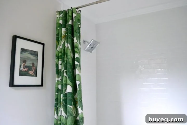 Elegant primary bathroom shower renovation showcasing white subway tile and a vibrant green shower curtain