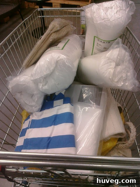 A large pile of IKEA flat-pack furniture and home decor items in a car trunk after a successful shopping trip.