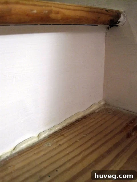 Applying GREAT STUFF foam sealant to stair gaps