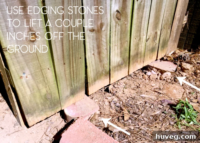 use edging stones to lift the fence panel off the ground