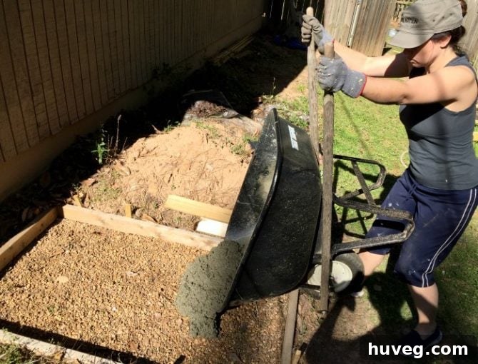 Pouring concrete from a wheelbarrow into the slab frame