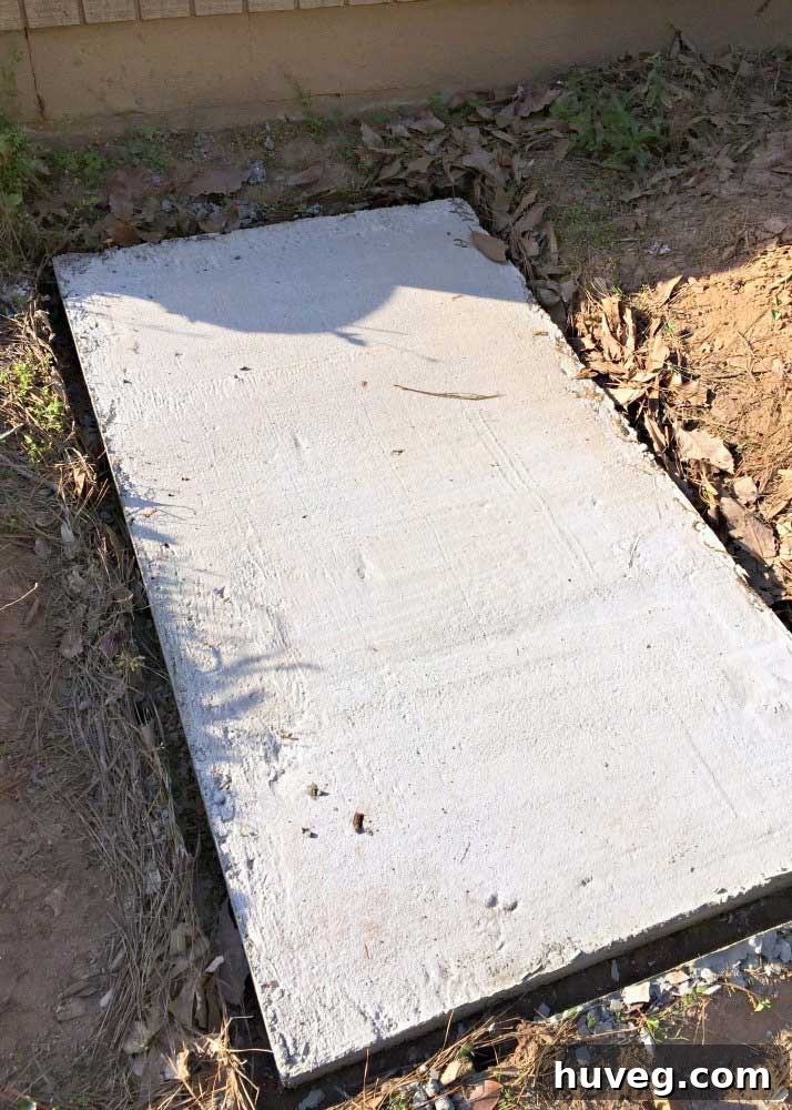 DIY concrete slab freshly poured on the side of the house with frame removed