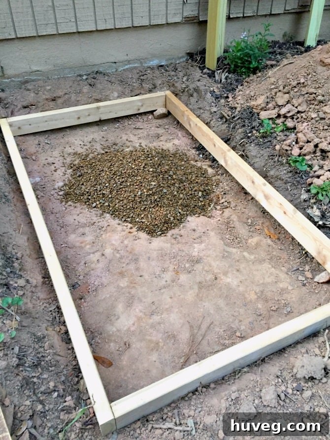 Pile of pea gravel inside a 2x4 frame for a concrete slab