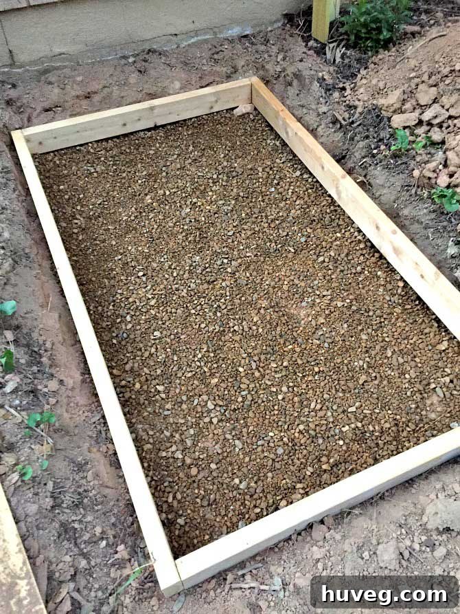 Pea gravel spread out and compacted under a 2x4 frame for a concrete slab