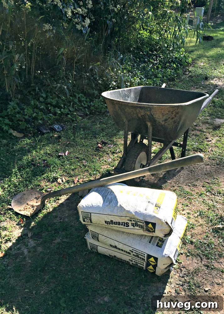 Wheelbarrow with bags of concrete mix and shovel ready for use