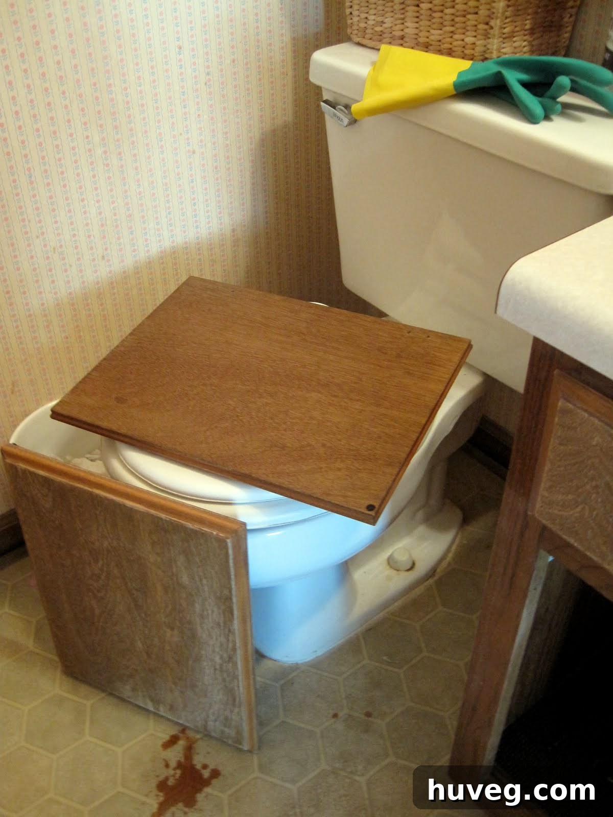 Space-saving tip: Dry cabinet doors on a toilet lid in compact bathrooms.