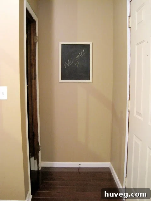 View from living room into downstairs entryway, showing continuous wall space.