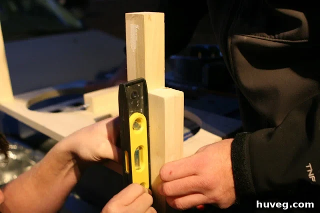 Checking dog bowl stand legs with a level for stability