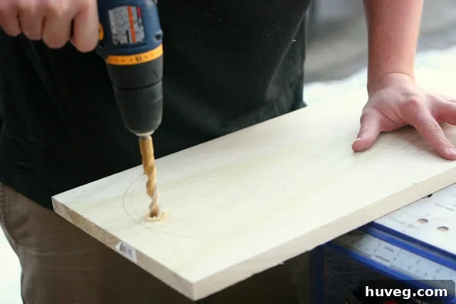 Drilling pilot hole for jigsaw blade on wood plank